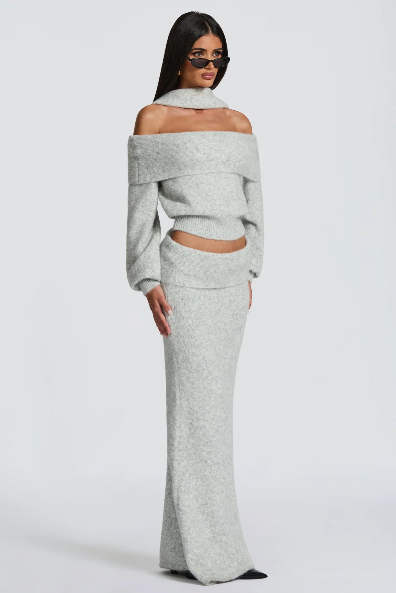 Set BIANCA composto da maglia off-shoulder e gonna lunga a sirena. Realizzato in morbida maglia calda, avvolge la silhouette con eleganza e comfort. Il design con collo ad anello e spalle scoperte aggiunge un tocco sofisticato e sensuale