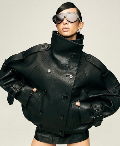 Eleva il tuo stile urbano con questo iconico giubbotto biker bomber oversize. Un capo che fonde la grinta della giacca in pelle al design d'avanguardia: caratterizzato da un imponente collo alto strutturato, allacciatura al petto