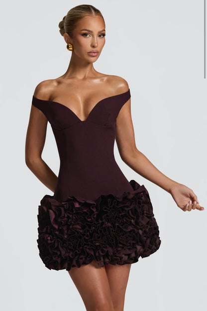 Mini Dress LIVIA 
Un mini dress raffinato e sofisticato, con scollo a cuore off-shoulder che valorizza il décolleté e una gonna arricchita da dettagli floreali tridimensionali. Perfetto per party, eventi esclusivi o come abito da cocktail