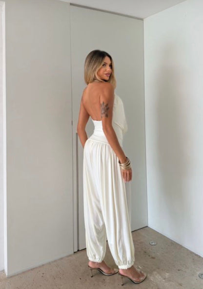 Jumpsuite Gioia Un'eleganza senza tempo racchiusa in una silhouette fluida e sensuale. La Tuta Drappeggiata è pensata per la donna che sa come catturare ogni sguardo senza sforzo.