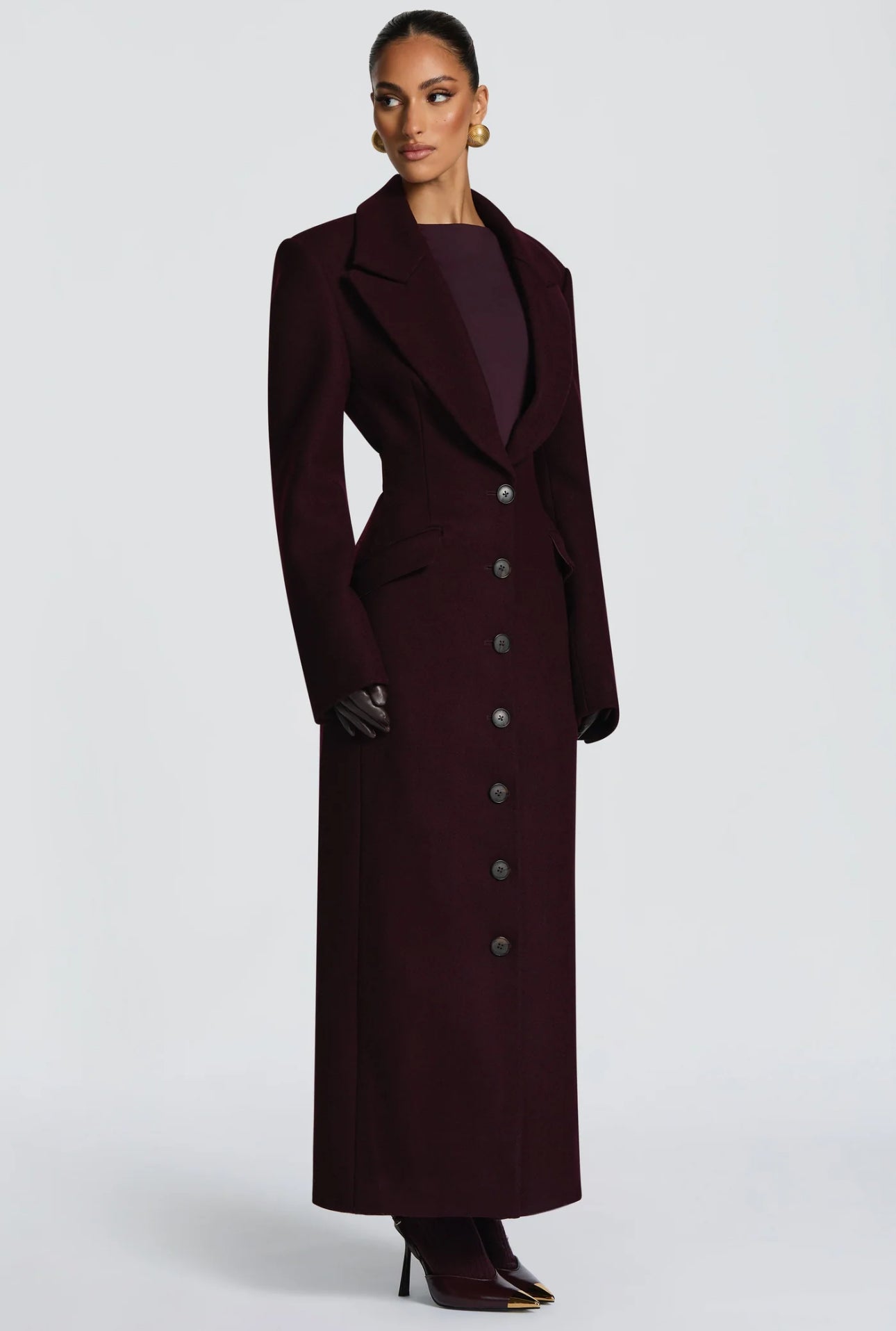 Cappotto ANGELICA lungo grigio in lana, con bottoni frontali e maxi revers a scialle. La linea dritta e sartoriale slancia la figura, mentre il colletto ampio aggiunge un tocco sofisticato. Perfetto per look invernali raffinati, dal giorno alla sera.