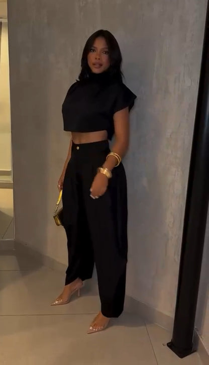 Set PRAGA Completo elegante composto da crop top a collo alto e pantaloni palazzo morbidi con pieghe frontali. Realizzato in tessuto fluido e leggero per una vestibilità confortevole e chic.