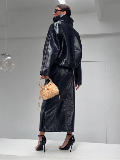 Co-ord Set in Similpelle Lucida Effect Noir
L'audacia incontra l'eleganza contemporanea. Eleva il tuo guardaroba con questo esclusivo coordinato a due pezzi, composto da una giacca bomber dallo stile urban-chic e una gonna midi dalla silhouette affusolata