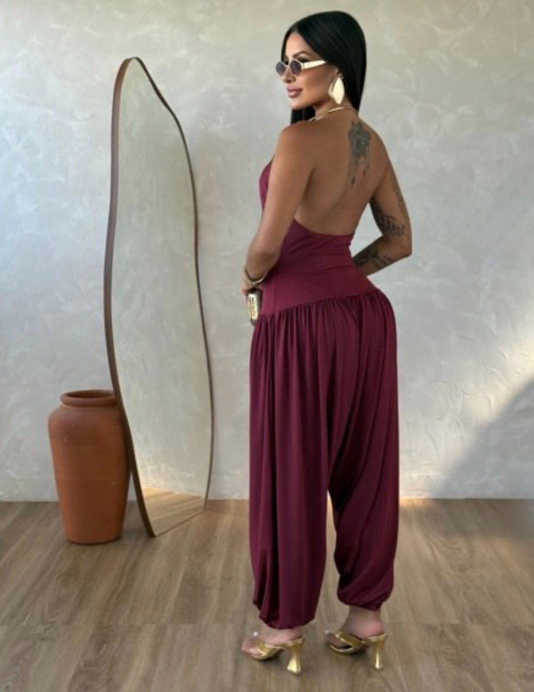 Jumpsuite Gioia Un'eleganza senza tempo racchiusa in una silhouette fluida e sensuale. La Tuta Drappeggiata è pensata per la donna che sa come catturare ogni sguardo senza sforzo.