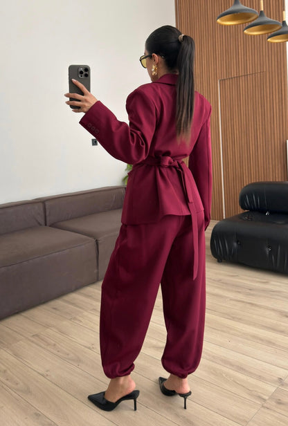 Tailleur Samantha”in promo” composto da giacca sartoriale con spalle strutturate e chiusura incrociata. La cintura integrata con bottoni decorativi stringe il punto vita valorizzando la silhouette e creando un elegante effetto corsetto l pantalone fluido