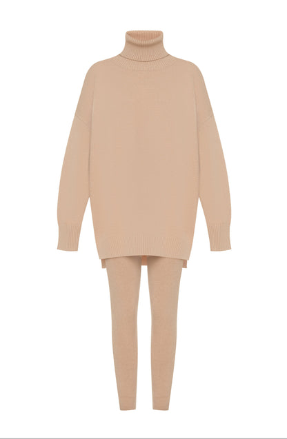 Coordinato ALBA indossa un coordinato in stile minimal e raffinato.
L'outfit è composto da un maxi maglione a collo alto in maglia con un design oversize e spacchetti laterali. È abbinato a pantaloni slim fit in coordinato