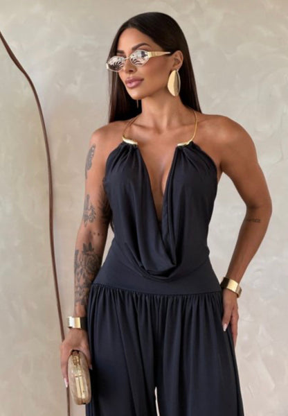 Jumpsuite Gioia Un'eleganza senza tempo racchiusa in una silhouette fluida e sensuale. La Tuta Drappeggiata è pensata per la donna che sa come catturare ogni sguardo senza sforzo.