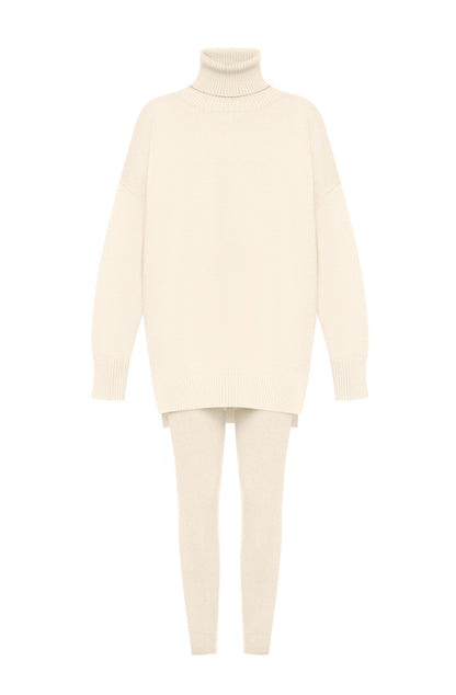 Coordinato ALBA indossa un coordinato in stile minimal e raffinato.
L'outfit è composto da un maxi maglione a collo alto in maglia con un design oversize e spacchetti laterali. È abbinato a pantaloni slim fit in coordinato