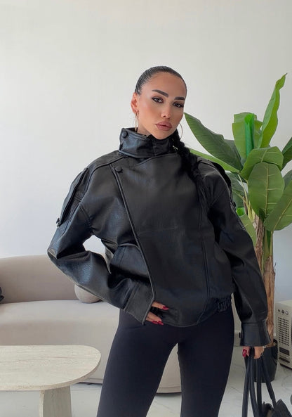 Giacca Biker Oversize in pelle Caratterizzata da una silhouette strutturata con spalle scese e un collo alto avvolgente con cinturino, è il capo spalla perfetto per completare i tuoi outfit streetwear ed eleganti con un tocco audace.