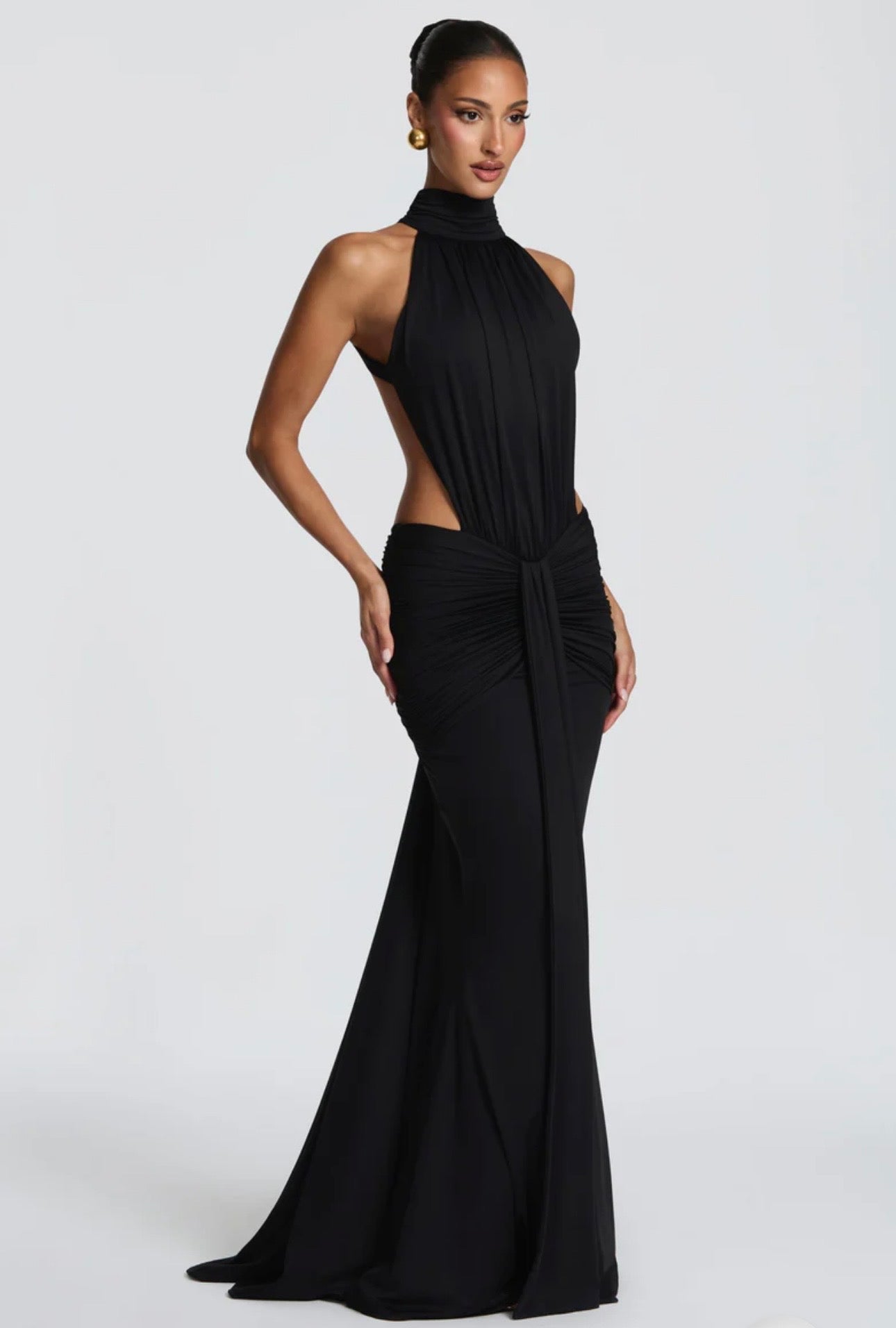 Abito Sofia Caratterizzato da una silhouette a sirena che valorizza le forme, questo modello unisce un sofisticato collo alto a un audace gioco di drappeggi e intagli cut-out sui fianchi.