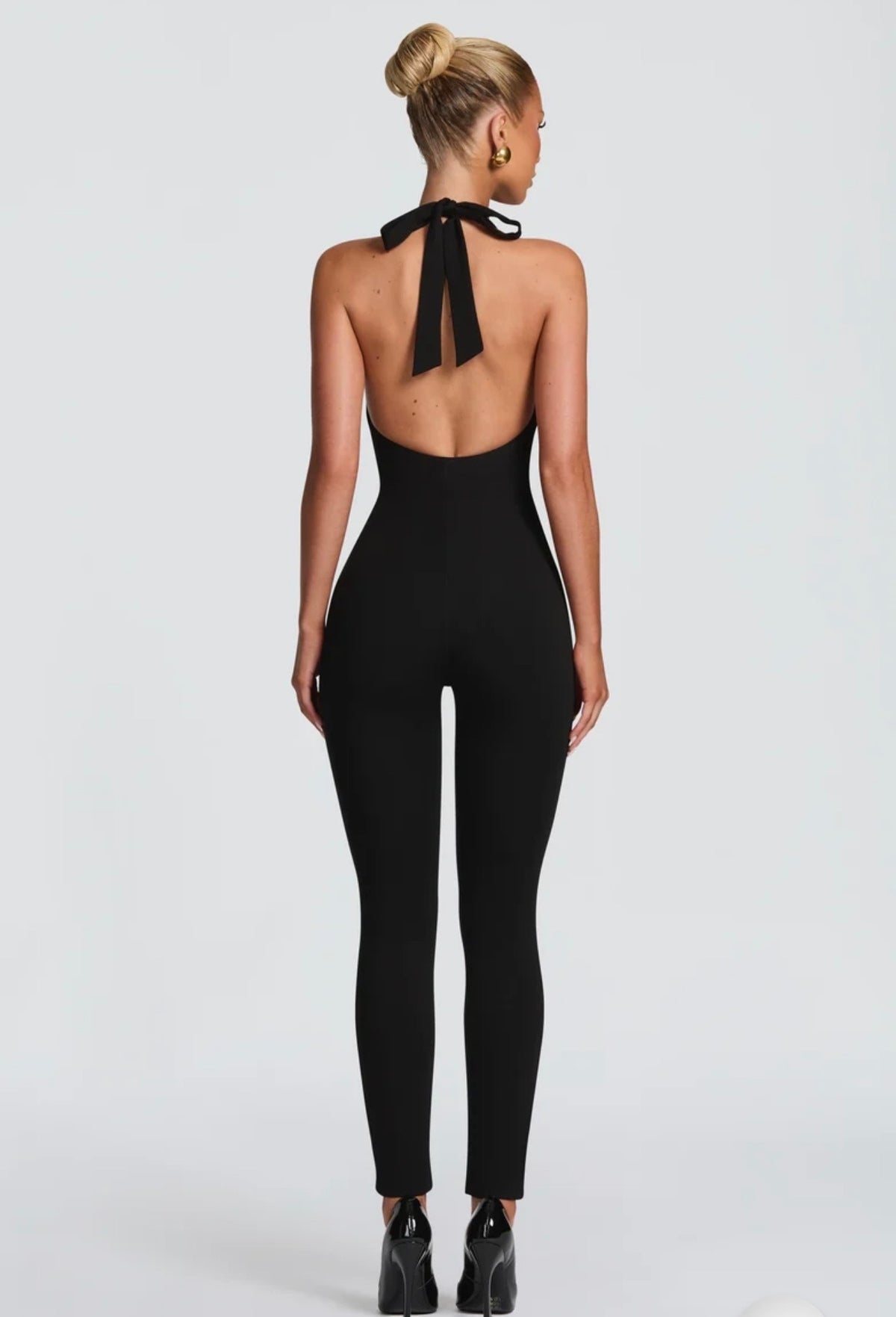 Tuta Intera Aderente Allacciata al Collo (Halter Jumpsuit) ultra-aderente con scollo all'americana e schiena scoperta. Un capo versatile e modellante che unisce eleganza minimale e sensualità, perfetto per serate ed eventi speciali.