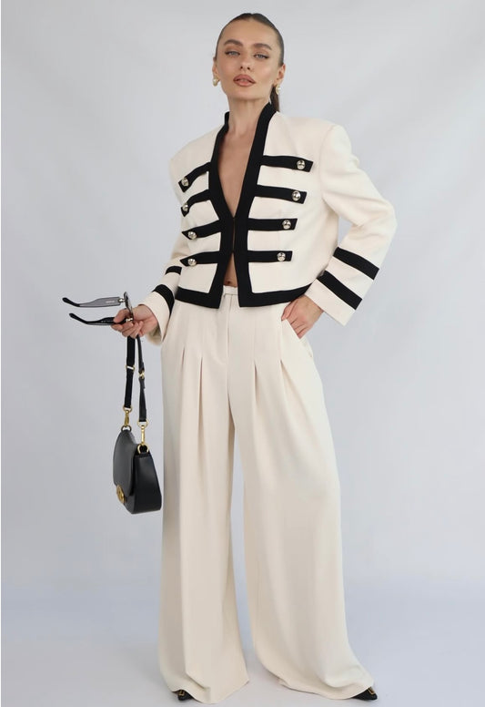 Victoria Set Completo raffinato dal fascino military-chic: giacca corta strutturata con dettagli a contrasto e pantalone palazzo fluido a vita alta. Elegante, moderno e perfetto per distinguersi con classe.