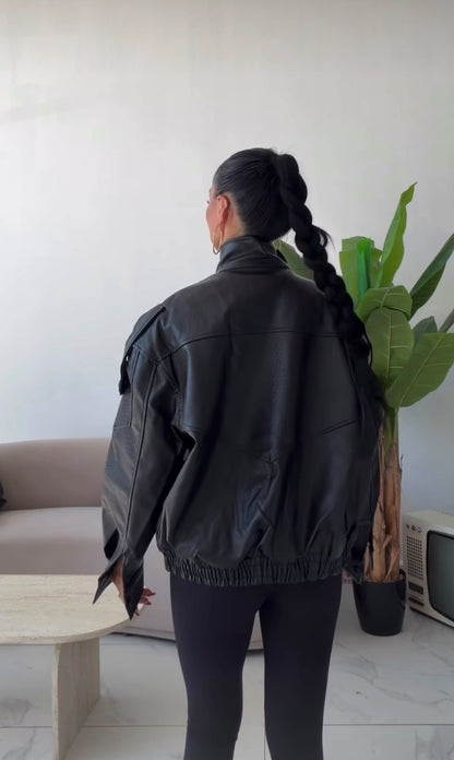 Giacca Biker Oversize in pelle Caratterizzata da una silhouette strutturata con spalle scese e un collo alto avvolgente con cinturino, è il capo spalla perfetto per completare i tuoi outfit streetwear ed eleganti con un tocco audace.