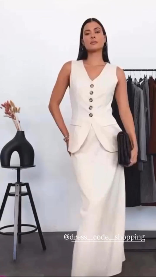 Tailleur ANTONELLA elegante in stile sartoriale è composto da un gilet senza maniche con scollo a V e chiusura a bottoni frontali. La gonna lunga e dritta si abbina perfettamente al gilet, creando un look sofisticato e minimalista