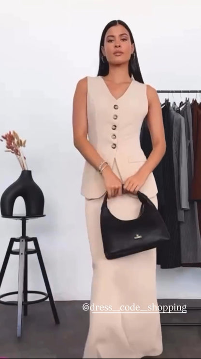 Tailleur ANTONELLA elegante in stile sartoriale è composto da un gilet senza maniche con scollo a V e chiusura a bottoni frontali. La gonna lunga e dritta si abbina perfettamente al gilet, creando un look sofisticato e minimalista