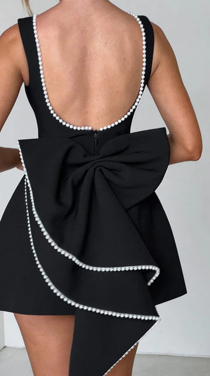 Mini Dress ALESSIA caratterizzato da un design sofisticato e femminile. Presenta una scollatura profonda sulla schiena, impreziosita da un bordo di perline che segue il profilo delle spalline e il décolleté posteriore…
