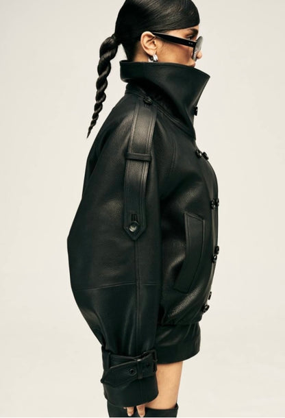 Eleva il tuo stile urbano con questo iconico giubbotto biker bomber oversize. Un capo che fonde la grinta della giacca in pelle al design d'avanguardia: caratterizzato da un imponente collo alto strutturato, allacciatura al petto