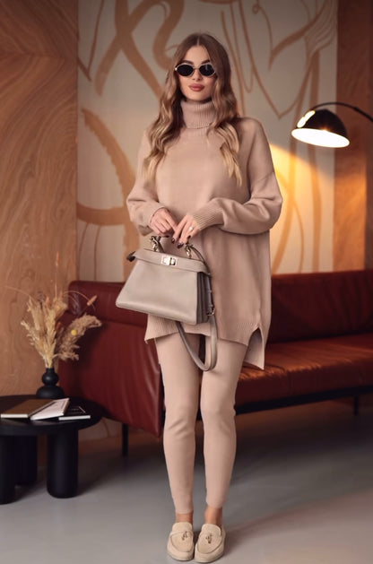 Coordinato ALBA indossa un coordinato in stile minimal e raffinato.
L'outfit è composto da un maxi maglione a collo alto in maglia con un design oversize e spacchetti laterali. È abbinato a pantaloni slim fit in coordinato