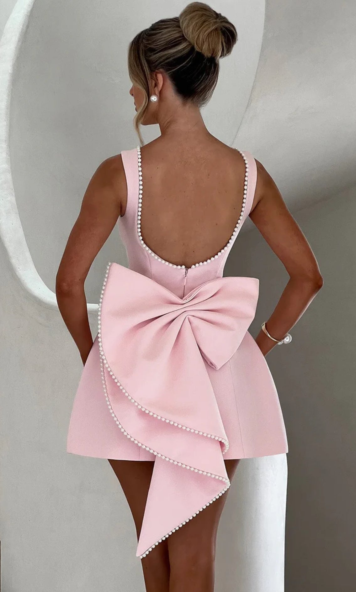 Mini Dress ALESSIA caratterizzato da un design sofisticato e femminile. Presenta una scollatura profonda sulla schiena, impreziosita da un bordo di perline che segue il profilo delle spalline e il décolleté posteriore…